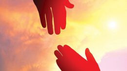 2 hands reaching toward each other against a red/orange cloudy sky