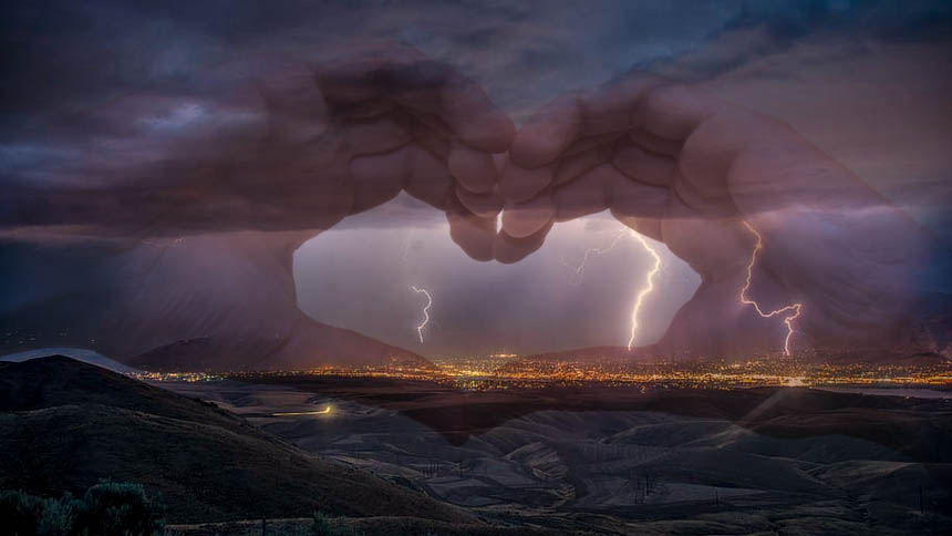 View of lighting over city at night, overlaid with hands forming a heart shape