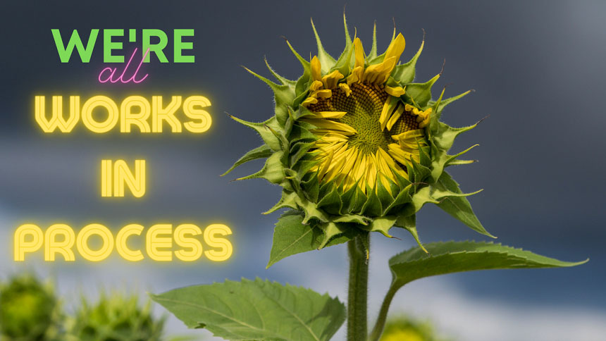 "WE'RE all WORKS IN PROCESS" overlaid on photo of partially-opened sunflower